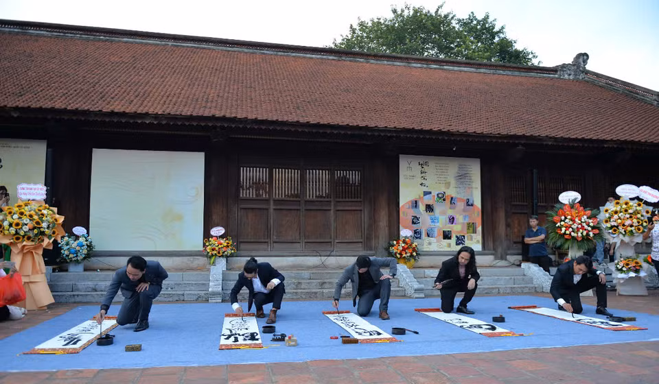 Los calígrafos demuestran sus habilidades en el Templo de la Literatura. (Fuente: Revista Vietnam)