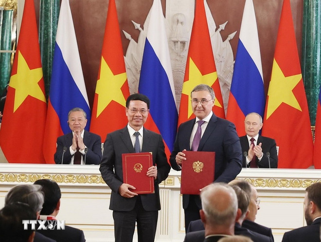 El secretario general del Partido Comunista de Vietnam, To Lam, y el presidente de Rusia, Vladimir Putin, presencian un acto de firma del acuerdo sobre la cooperación en tecnología. (Fuente: VNA) chung.jpg