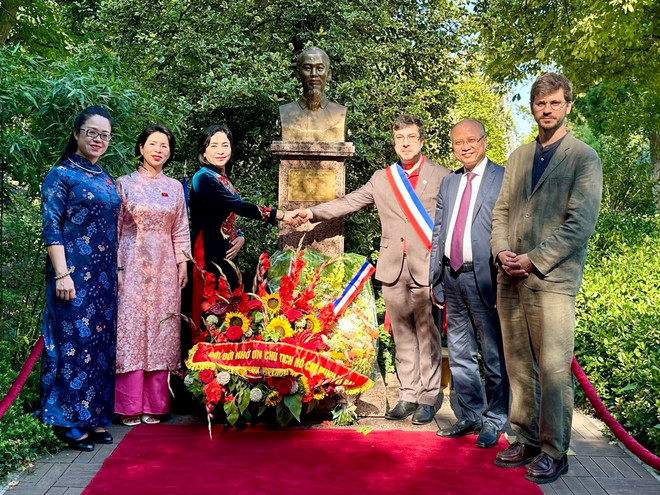 Los delegados toman fotos de recuerdo frente a la estatua del Tío Ho en el parque Montreau. (Fuente: VNA) thanh.jpg