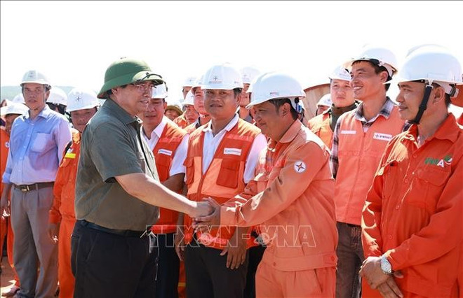 El primer ministro Pham Minh Chinh con ingenieros y trabajadores que construyen el proyecto de la línea de transmisión de 500 kV Lao Cai - Vinh Yen. (Fuente: VNA) pham-minh-chinh-2.jpg