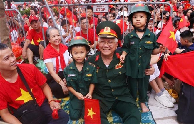 Un veterano y niños llegan temprano para presenciar el segundo ensayo. (Fuente: VNA) cuu.jpg