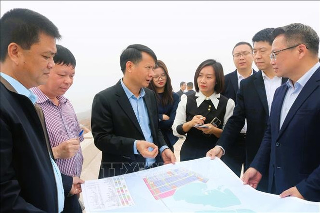 Delegados de ambas partes estudian el proyecto. (Fuente: VNA) ckqt-mong-cai-dong-hung-cua-khau-thong-minh-11032025-03.jpg