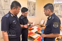 Agentes de aduanas inspeccionan un envío de presuntos teléfonos móviles usados ​​en tránsito que carece de la documentación de origen adecuada (Foto: VNA).