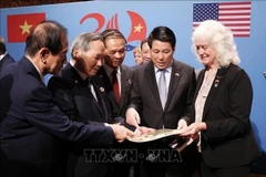 El presidente Luong Cuong (segundo a la derecha) en el intercambio de recuerdos para las familias de los soldados vietnamitas y estadounidenses. (Foto: VNA)