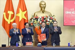 El primer ministro Pham Minh Chinh (segundo desde la izquierda) y el presidente de la Asamblea Nacional, Tran Thanh Man (extrema derecha), presentan la decisión del nombramiento y ofrecen flores a Nguyen Hong Dien. (Foto: VNA)