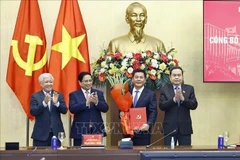 El primer ministro Pham Minh Chinh (segundo desde la izquierda) y el presidente de la Asamblea Nacional, Tran Thanh Man (extrema derecha), presentan la decisión del nombramiento y ofrecen flores a Nguyen Hong Dien. (Foto: VNA)