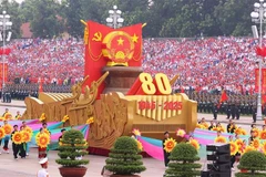 Un vehículo en miniatura con el emblema nacional de la República Socialista de Vietnam encabeza el desfile militar y la procesión multitudinaria. (Foto: VNA)