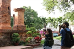 Dos turistas rusos toman fotos con entusiasmo en la reliquia de la Torre Ponagar (Khanh Hoa). (Foto: VNA)