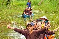 Los turistas disfrutan de recorrer el bosque en sampán en el sitio de ecoturismo. (Foto: VNA)