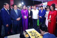 El primer ministro Pham Minh Chinh visita un stand vietnamita en el evento (Foto: VNA)