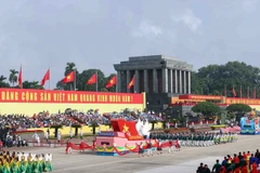 Representantes de vietnamitas en el extranjero marchando por el escenario de la ceremonia. (Foto: VNA)