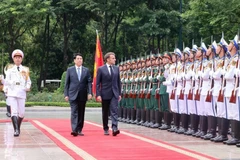 El presidente Luong Cuong (izquierda) y su homólogo francés, Emmanuel Macron, pasan revista a la Guardia de Honor del Ejército Popular de Vietnam. (Foto: VNA)