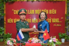 El mayor general Luu Trong Lu, presidente de la Asociación de Veteranos de Guerra de la provincia de Dien Bien, entrega la vasija de tierra a Vu Thi Tuyet Nga, directora del Museo de la Victoria de Dien Bien Phu. (Foto: VNA)