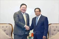 El primer ministro Pham Minh Chinh (der.) recibe a Thammasak Sethaudom, presidente y director ejecutivo de SCG Group. (Foto: VNA)