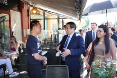 El primer ministro Pham Minh Chinh y su esposa visitan a empresarios vietnamitas en el casco antiguo de Niza. (Foto: VNA)