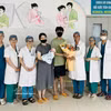 El personal médico del Hospital de Obstetricia y Pediatría de Da Nang entrega flores para felicitar a los padres y al bebé al momento del alta hospitalaria. (Foto: VNA)