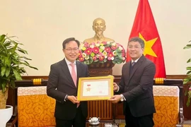 El viceministro permanente de Relaciones Exteriores Nguyen Minh Vu entregó la medalla conmemorativa “Por la causa de la diplomacia vietnamita” al director general del grupo surcoreano Samsung en el país indochino, Choi Joo Ho. (Fuente: VNA)