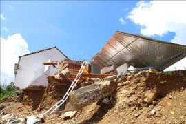 Casas en la aldea de Vang Mon (comuna de Nga My, provincia de Nghe An) se derrumbaron en el arroyo debido a inundaciones repentinas. (Foto: VNA)