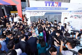 Reporteros informan sobre el stand de la Agencia de Noticias de Vietnam en el Festival Nacional de Prensa 2022. (Fuente: VNA)