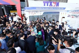 Reporteros informan sobre el stand de la Agencia de Noticias de Vietnam en el Festival Nacional de Prensa 2022. (Fuente: VNA)