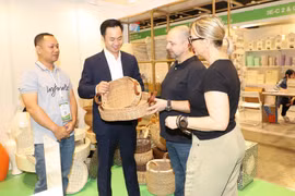 Clientes internacionales aprenden sobre los productos artesanales vietnamitas. (Fuente: VNA)
