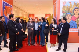 La subdirectora general de la Agencia de Noticias de Vietnam, Nguyen Thi Su, presenta la exposición fotográfica de la entidad en el XI Congreso Nacional de Emulación Patriótica a la vicepresidenta Vo Thi Anh Xuan. (Fuente: VNA)