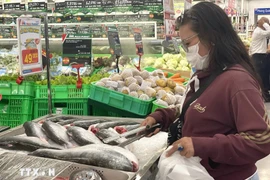 Los consumidores eligen productos del mar en un supermercado. (Foto: VNA)