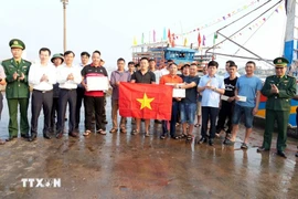 El vicepresidente del Comité Popular Provincial de Quang Tri, Le Van Bao (fila superior, cuarto desde la derecha), entrega regalos y recuerda a los pescadores el estricto cumplimiento de las normas contra la pesca IUU. (Foto: VNA)