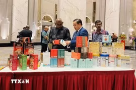 El consejero comercial vietnamita en Malasia, Le Phu Cuong (en el centro), presenta productos tradicionales vietnamitas a los invitados. (Fuente: VNA)