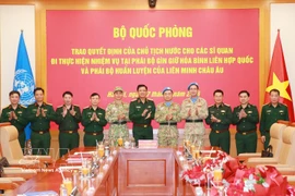 El coronel general Nguyen Truong Thang, viceministro de Defensa, y representantes de la cartera felicitan a los oficiales participantes. (Fuente: VNA)