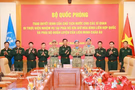 El coronel general Nguyen Truong Thang, viceministro de Defensa, y representantes de la cartera felicitan a los oficiales participantes. (Fuente: VNA)