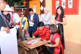 Vietnamitas en el extranjero hacen fila para pedir caligrafía. (Fuente: VNA)