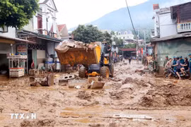 Se movilizaron excavadoras para nivelar y recoger el lodo, las ramas de árboles y la basura arrastrada por la reciente inundación en la comuna de Song Ma, provincia de Son La. (Foto: VNA)