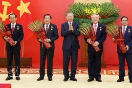 El secretario general del Partido Comunista de Vietnam (PCV), To Lam (centro) entrega Orden del Mérito Militar y de insignias de membresía del PCV a dirigentes y exlíderes del Partido y del Estado. (Fuente: VNA)