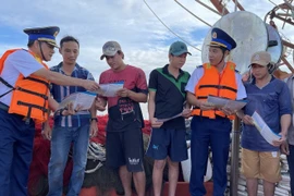 Las fuerzas encargadas de hacer cumplir la ley marítima difunden información sobre la pesca IUU entre los pescadores. (Foto: VNA)