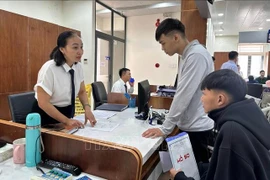 Funcionarios del Centro de Administración Pública del Distrito de Tam Ky, en la ciudad de Da Nang, guían a los ciudadanos en los trámites. (Foto: VNA)