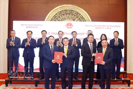 En la firma de acuerdos de cooperación entre empresas vietnamitas y chinas. (Foto: VNA)