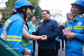 El primer ministro Pham Minh Chinh y trabajadores ambientales. (Fuente: VNA)
