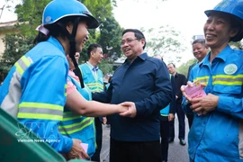 El primer ministro Pham Minh Chinh y trabajadores ambientales. (Fuente: VNA)