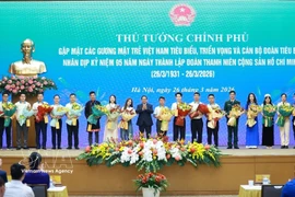 El primer ministro Pham Minh Chinh entrega flores para felicitar a los jóvenes vietnamitas destacados. (Fuente: VNA)