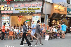 Turistas extranjeros disfrutan de la gastronomía en la calle Ta Hien, Hanoi. (Foto: VNA)