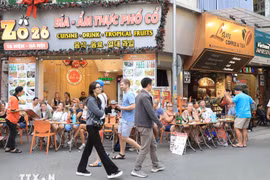 Turistas extranjeros disfrutan de la gastronomía en la calle Ta Hien, Hanoi. (Foto: VNA)