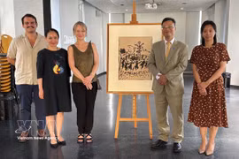 Delegados vietnamitas y franceses posan para una foto conmemorativa junto a la pintura original "¡Viva la paz!" de artista Pablo Picasso. (Fuente: VNA)
