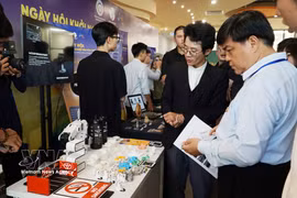 Visitantes en la exposición de productos tecnológicos y culturales. (Foto: VNA)