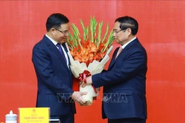 El primer ministro de Vietnam, Pham Minh Chinh, entrega la decisión de nombrar a Le Manh Hung, como ministro interino de Industria y Comercio. (Fuente: VNA)