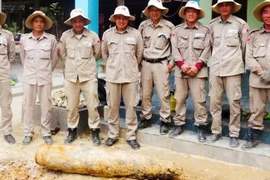 El personal de PeaceTrees Vietnam traslada la bomba de forma segura al lugar de detonación designado. (Foto: nhandan.vn)