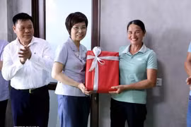 La directora general de la VNA, Vu Viet Trang, entrega obsequio a una familia que recibió apoyo de la agencia para construir una nueva casa. (Foto: VNA)