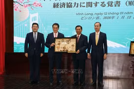 El secretario del Comité del Partido de Vinh Long, Tran Van Lau, entrega un obsequio conmemorativo a Tokihiro Nakamura, gobernador de la prefectura de Ehime, Japón. (Foto: VNA)