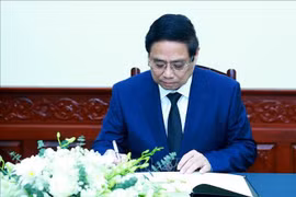 El primer ministro de Vietnam, Pham Minh Chinh, escribe en el libro de condolencias. (Fuente: VNA)