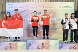 Los atletas vietnamitas Le Thi Mong Tuyen y Nguyen Thanh Nam en la ceremonia de entrega de medalla de oro. (Fuente: https://www.qdnd.vn/)